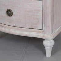 A solid hardwood three draw bedside table made from bleached mahogeny wood with ash veneers in a white wash finish. 