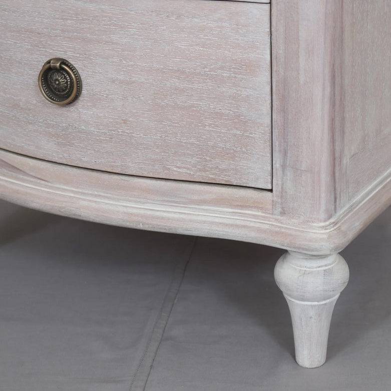 A solid hardwood three draw bedside table made from bleached mahogeny wood with ash veneers in a white wash finish. 
