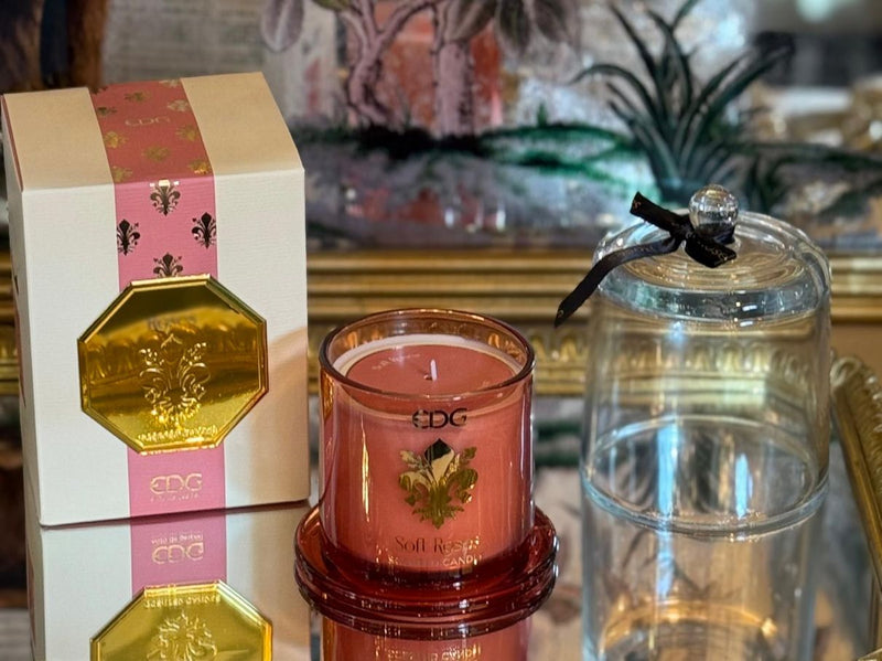 Soft Rose scented candle in pink glass with gold emblem and clear cloche, presented in a matching pink and gold gift box.