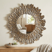 Vintage style metal sun mirror over a wooden cabinet in a cosy living room with chair and throws.