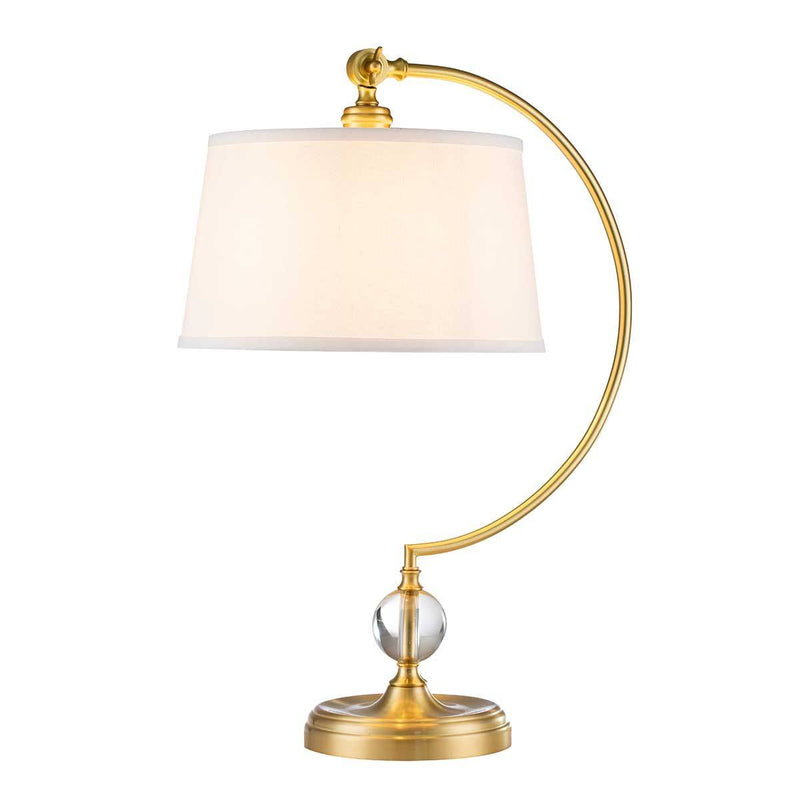 Table lamp with gold arm and white shade on a white background