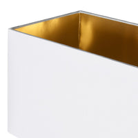 A luxurious looking tall gilt metal lamp with rectangular white shade with a gold lining adding to the overall warm gold glow of the entire piece. A total stylish statement lamp.