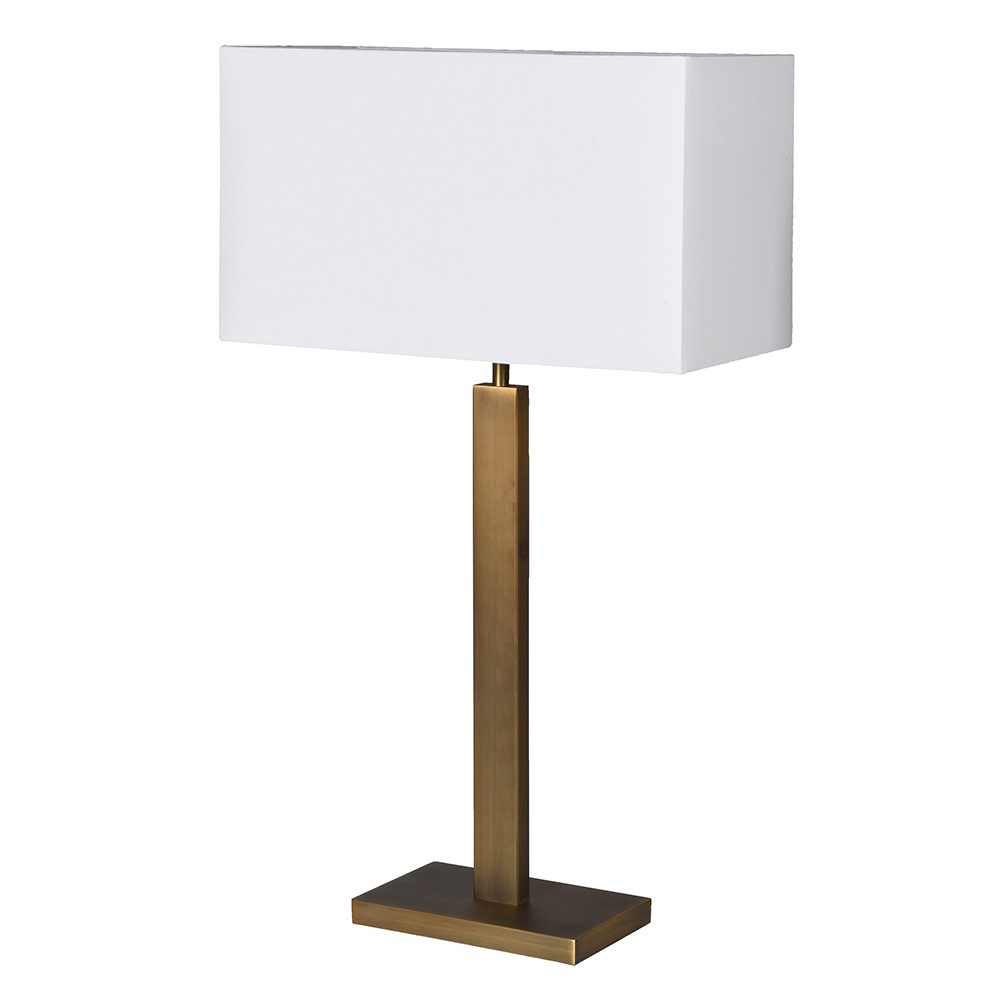 Tall gilt metal lamp with rectangular white shade with a gold lining adding to the overall warm gold glow