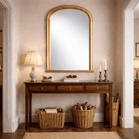 all gilt overmantle mirror with arched top, gold frame above fireplace in traditional country home hallway