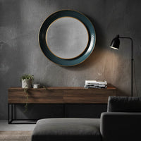 Teal circular wall mirror above a sofa in a mid century style living room.