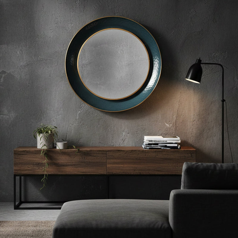 Teal circular wall mirror above a sofa in a mid century style living room.