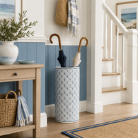Decorative umbrella stand with two umbrellas in a home interior setting.