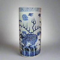 Large blue and white porcelain umbrella stand featuring traditional dragon and cloud motifs  on white background