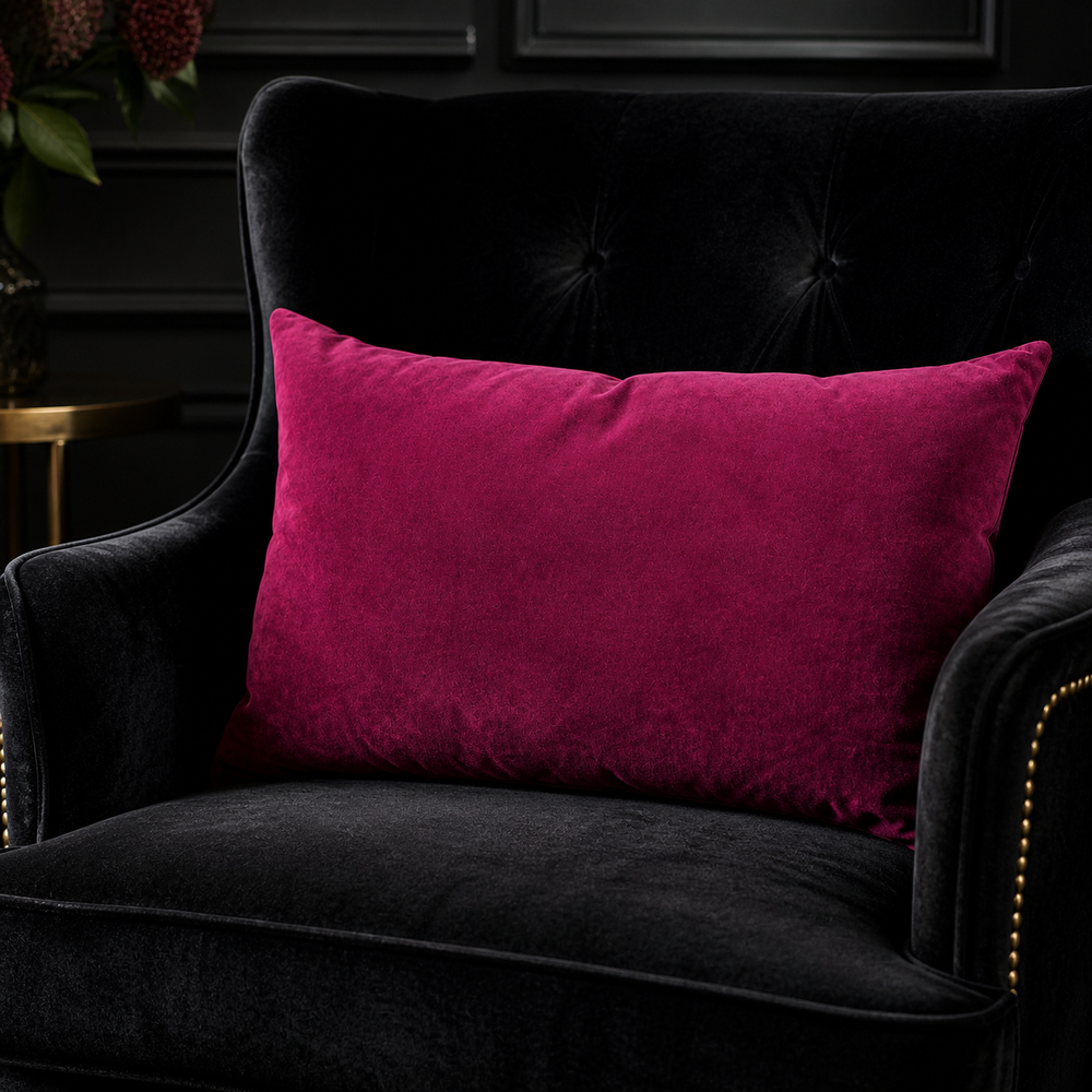 Pink pillow on a dark gray armchair with a blurred background