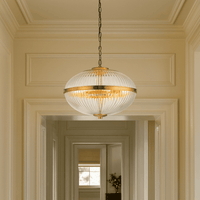 This elegant globe pendant light features a ribbed glass shade with a warm brass finish, blending vintage charm with modern appeal. I