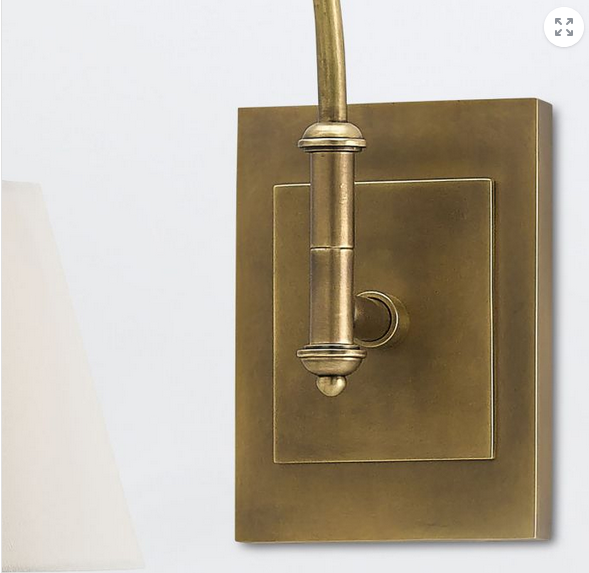 Brass wall-mounted light fixture on a white background