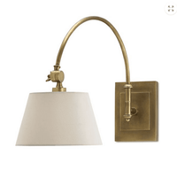 Wall-mounted lamp with beige shade and brass fixture on a white background
