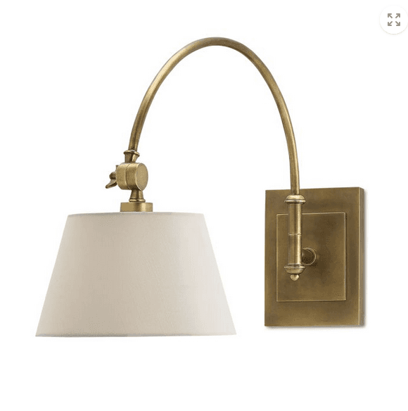 Wall-mounted lamp with beige shade and brass fixture on a white background