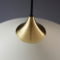 A wide, softly curved white dome pendant with warm brass detailing and a slim black suspension rod.