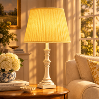 Pleated yellow fabric shade and a distressed white turned wood base in a living room