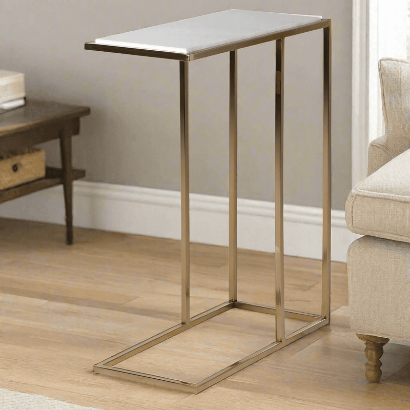 Modern side table with a white marble top and brushed gold metal legs, designed to slide under a sofa. Compact and stylish, ideal for space-saving decor.