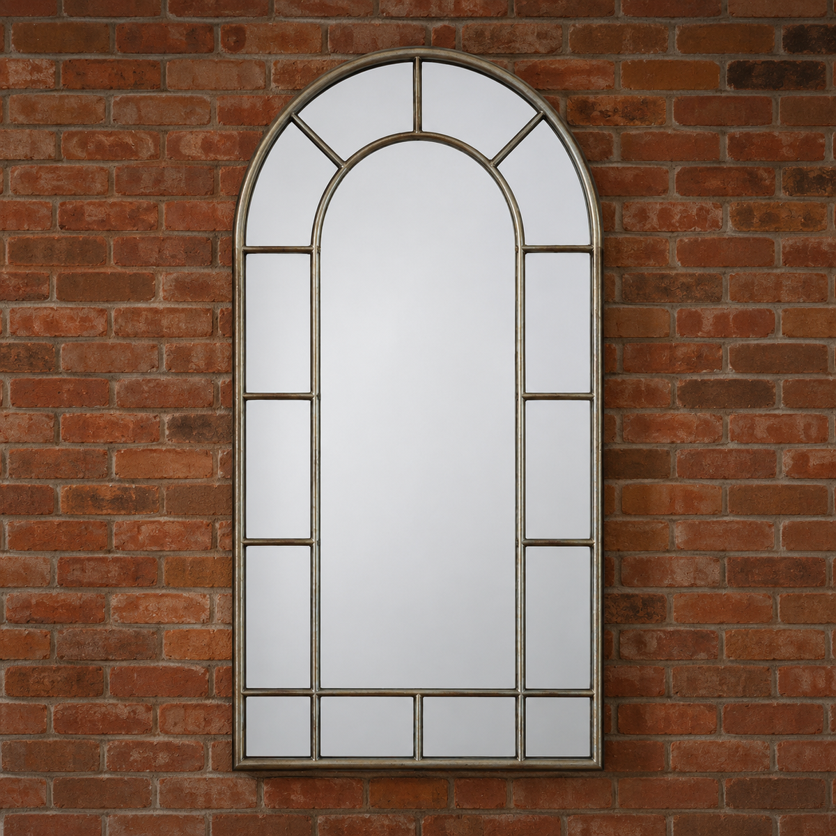 Arched window mirror on a brick wall.