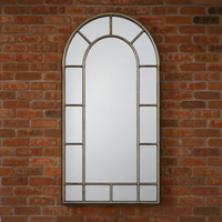 Arched window mirror on a brick wall.