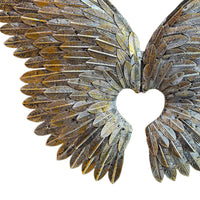 Decorative angel wings with a heart cutout on a white background