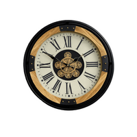 industrial wall clock with exposed moving gears, black metal frame, wood accents, and Roman numeral dial mounted on a dark paneled wall.