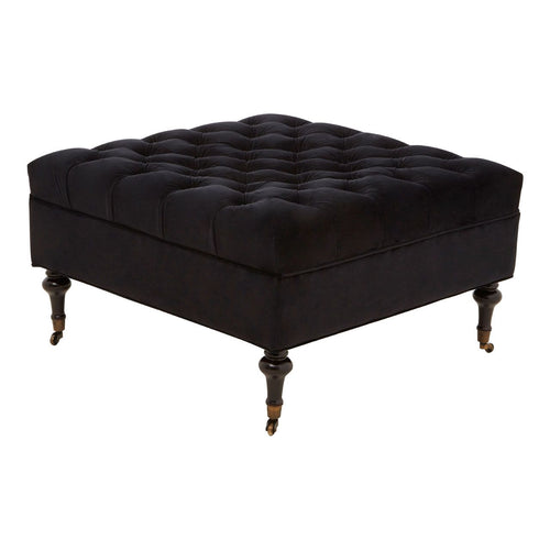A luxurious Black Velvet Footstool with its four legs made from natural wood, with copper metal hoods just above the castor wheels.