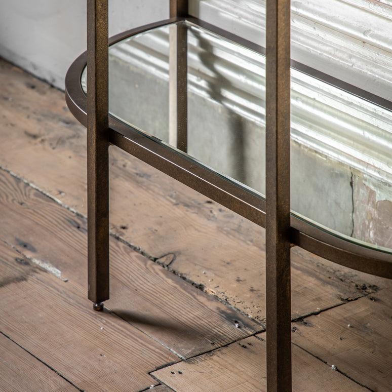 A Beautiful 3 tier shelf display unit with an elegant curved shape. The 3 glass shelf inserts and a mirror glass bottom shelf sit in a vintage bronze metal frame. 