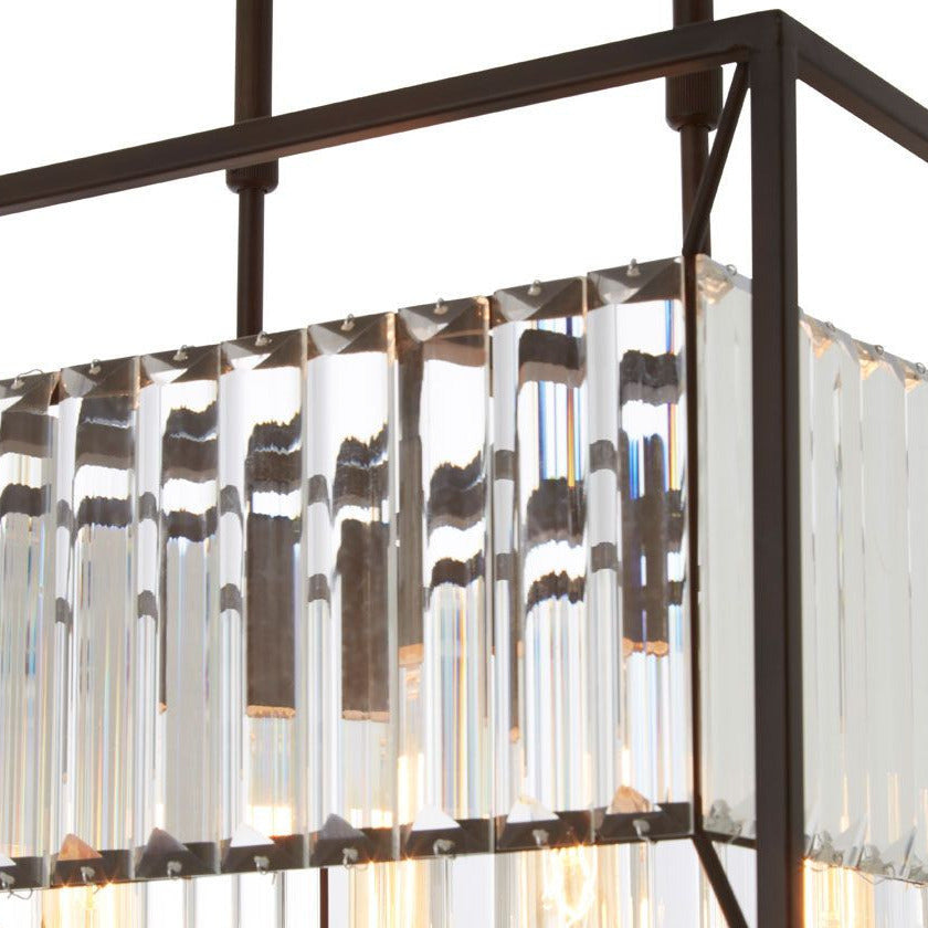 Rectangular industrial caged chandelier with clear glass rods and dark metal frame hanging over a modern kitchen ceiling