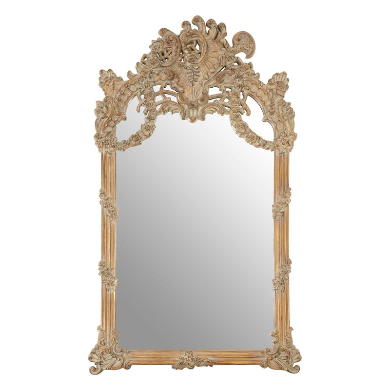 An oversized ornate mirror in a weathered, limewashed finish.