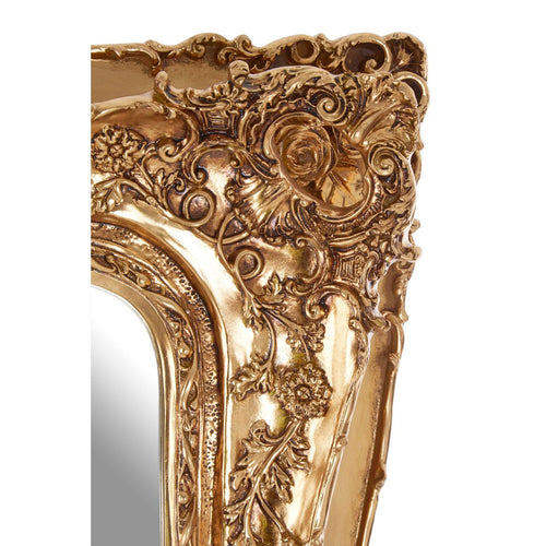 Tall, rectangular, ornate gilt mirror with heaviley decorated frame in a swept style.