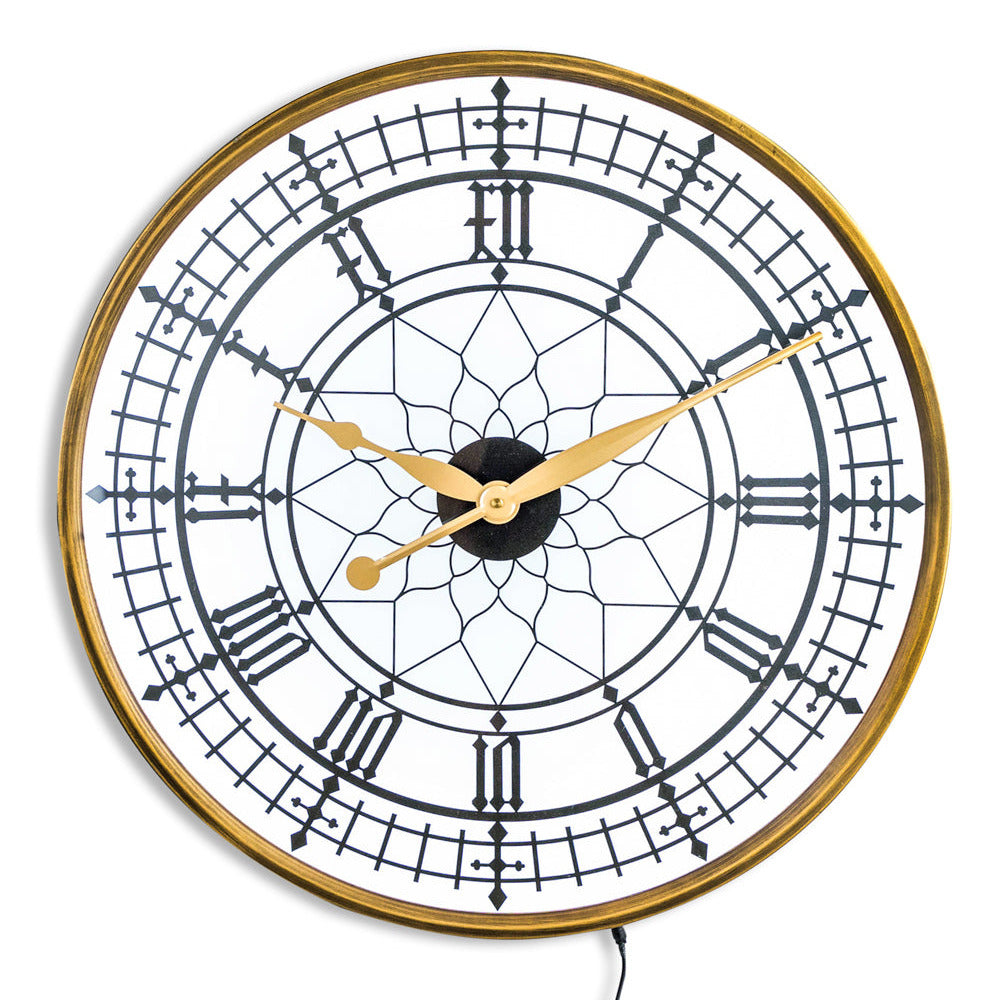 Decorative wall clock with gold frame and black face on a white background