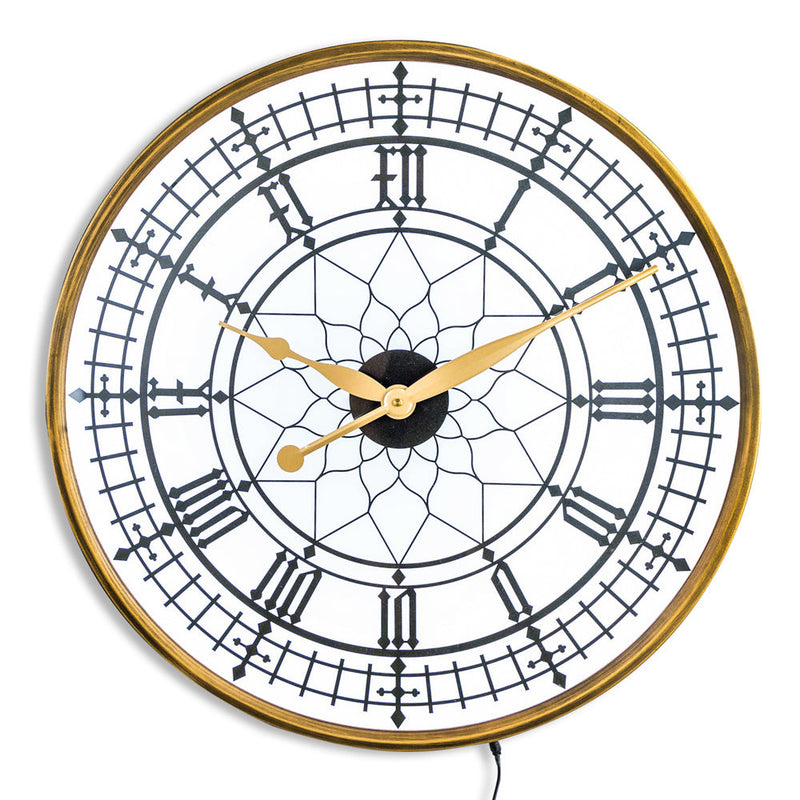 Decorative wall clock with gold frame and black face on a white background